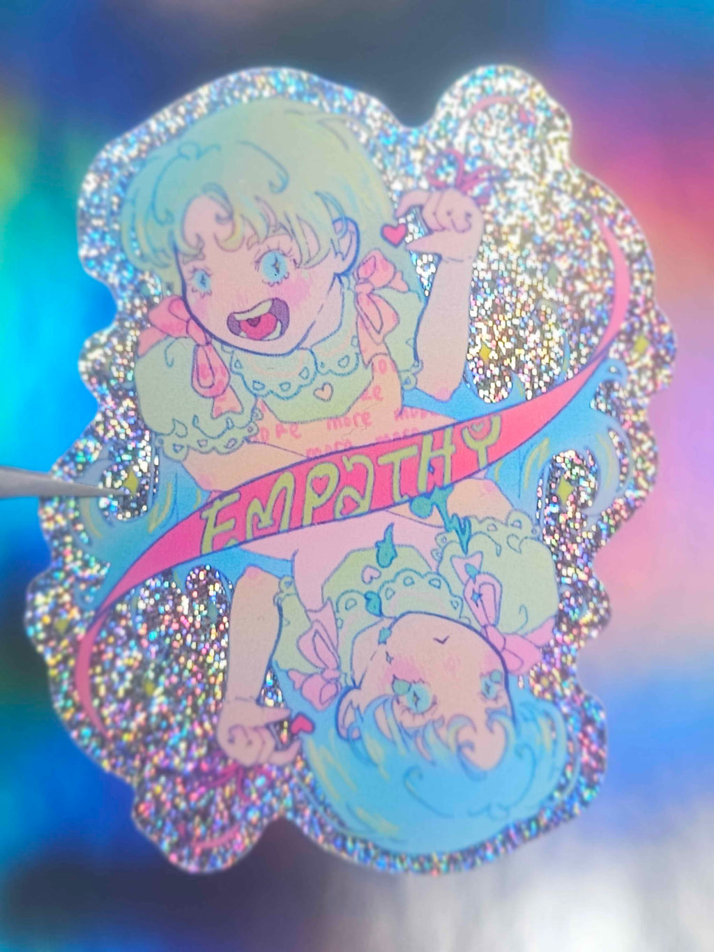 Glittery card with a character holding a banner labeled 'Empathy' on a colorful background