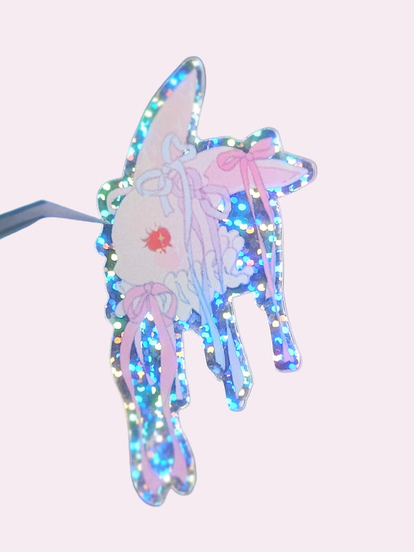 Coquette Bunny Die-Cut Sticker — approximately 3 inch waterproof vinyl sticker featuring an original hand-drawn illustration of a cute bunny head adorned with ribbons and surrounded by sparkles, whimsical coquette aesthetic artwork by indie artist Ailyse of Finding Wonderland