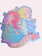 Less Apathy holographic glitter die-cut sticker — two figures of different genders turned away from each other, the word "less" woven as a pattern into one figure's dress, original Signature Collection artwork by Ailyse of Finding Wonderland