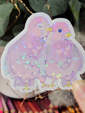 Close-up of Wander Pigeons holographic sticker showing glitter shimmer and hand-drawn feather detail
