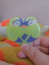 Close-up of Wander Bird hairclip showing glossy resin coating and hand-illustrated bird face detail