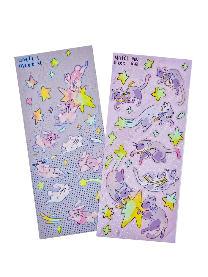 Until I Meet You and Until You Meet Me sticker sheets — holographic Little Wonders collection sticker sheets featuring Double Lucky the bunny and Funny Bunny the cat floating through a starry night sky, original artwork by indie artist Ailyse of Finding Wonderland